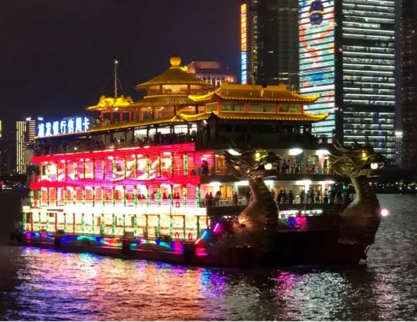 A dragon boat lit up on the river