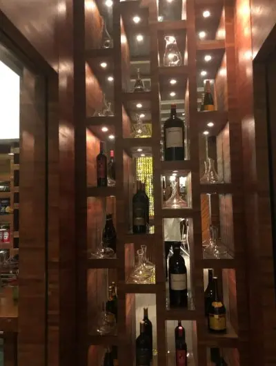 A wall of wine, lit bottle by bottle